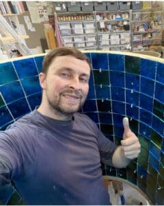 Antony fixing tiles to the rings for Glasgow's Wellspring